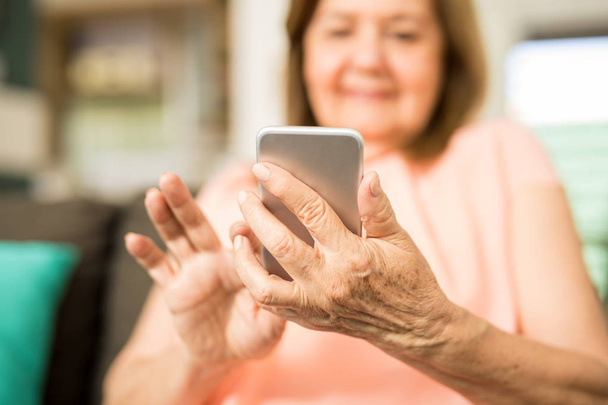 Λατινική γιαγιά χρησιμοποιώντας smartphone  - Φωτογραφία, εικόνα