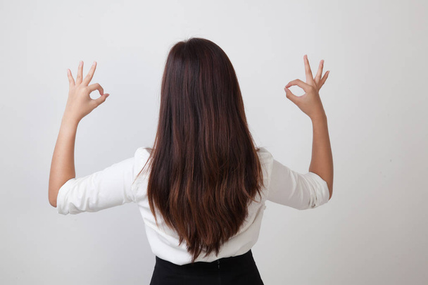 Vista posterior de la mujer asiática muestran doble signo de mano OK
. - Foto, imagen