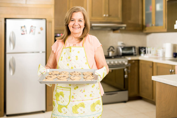 Mujer mostrando galletas recién horneadas
  - Foto, Imagen