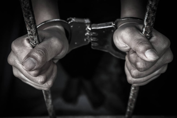 Mano humana sosteniendo barra de prisión
 - Foto, imagen