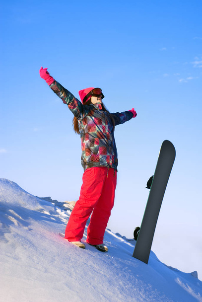 happy girl standing on a mountain top with snowboard - Photo, Image