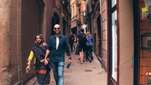 BARCELONA, SPAIN - APRIL, 15, 2017. Tourists walk along narrow pedestrian old town street - Fotó, kép