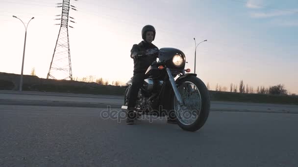 mies, jolla on moottoripyörä auringonlaskun aikaan
 - Materiaali, video