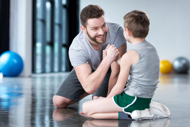 Jongen met jonge man bij fitness center - Foto, afbeelding