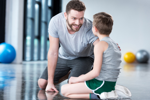 Boy with young man at fitness center - Фото, изображение