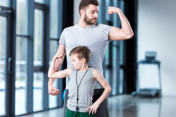 Menino com jovem mostrando músculos
  - Foto, Imagem