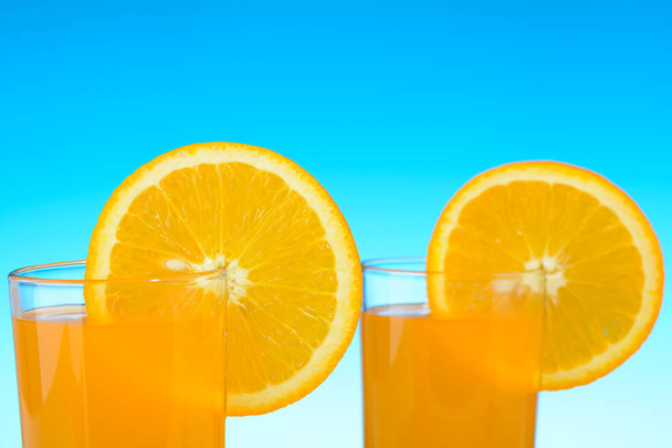Dwie szklanki soku pomarańczowego na plaży - Zdjęcie, obraz