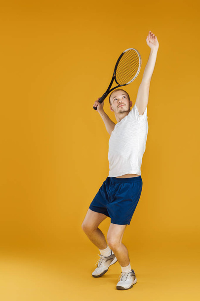 young tennis player plays tennis on yellow background - Zdjęcie, obraz