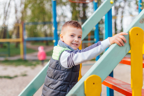 Little boy play on playground with blur park background - Фото, зображення