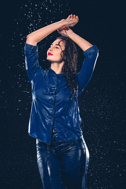 Young beautiful woman under splash of rain - 写真・画像