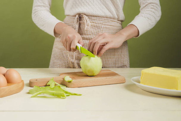 женщина режет зеленое яблоко
 - Фото, изображение