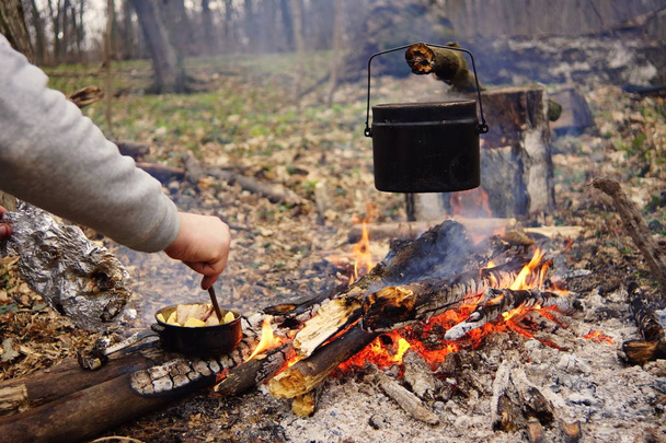 Preparación de comida en fogata en camping salvaje como
 - Foto, imagen