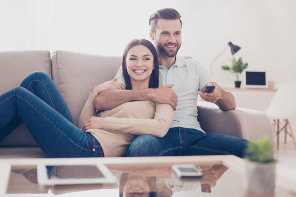 Cheerful couple is watching tv together and having fun. They are - Φωτογραφία, εικόνα