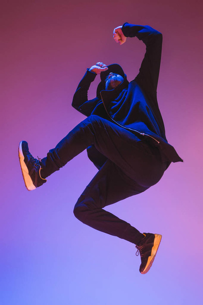 The silhouette of one hip hop male break dancer dancing on colorful background - Foto, immagini