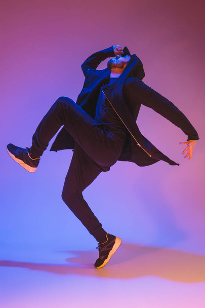 The silhouette of one hip hop male break dancer dancing on colorful background - Photo, Image