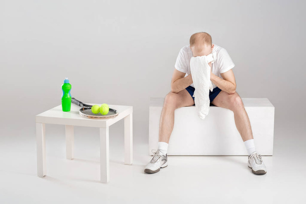 young tennis player with towel resting after workout - Foto, afbeelding