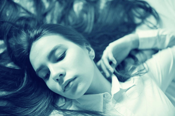 teenage girl with long hair in bed - Fotó, kép
