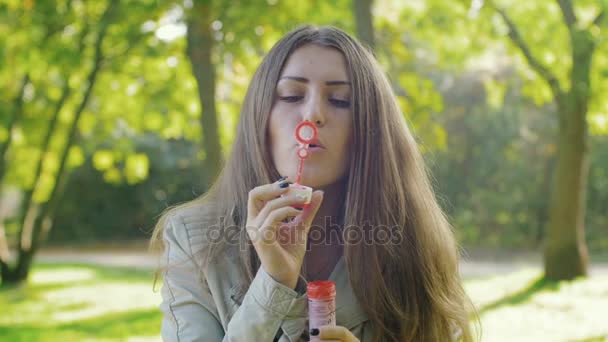 woman make bubbles in park - Materiał filmowy, wideo
