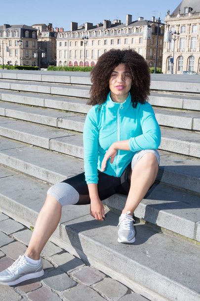 cheerful sport active woman sitting on the city - Foto, Imagem