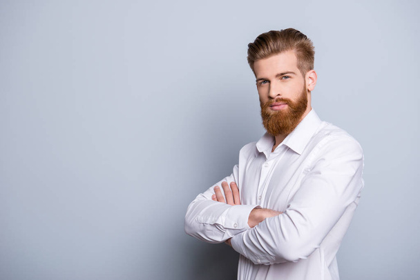 Half-profile portrait of serious confident bearded man keeping   - Foto, afbeelding