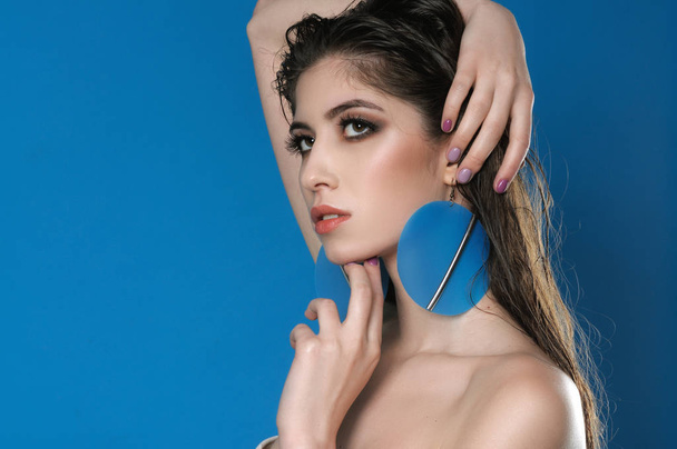 Portrait of a beautiful girl with big round blue earrings - Fotografie, Obrázek