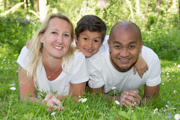 matka i ojciec z synem mieszane chłopiec w trawie w lecie z miłości - Zdjęcie, obraz
