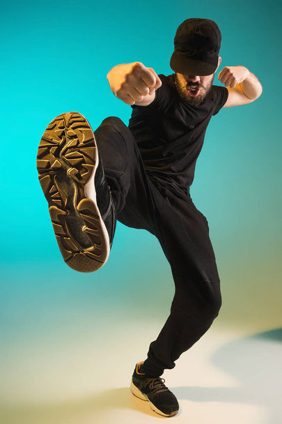 The silhouette of one hip hop male break dancer dancing on colorful background - Фото, изображение