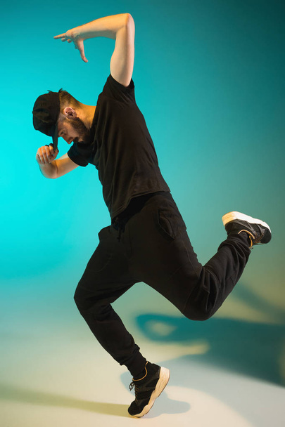 The silhouette of one hip hop male break dancer dancing on colorful background - Fotó, kép