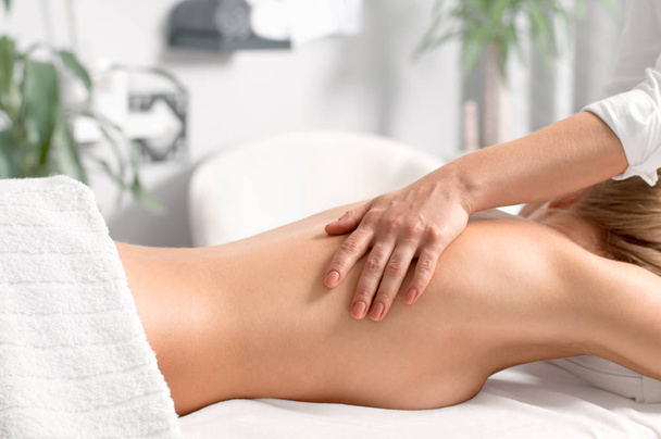 Woman having massage of body in the spa salon. - Foto, afbeelding