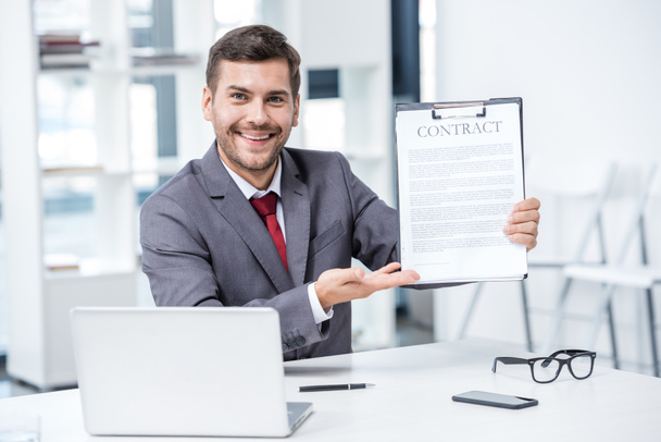 Businessman holding contract  - Foto, afbeelding
