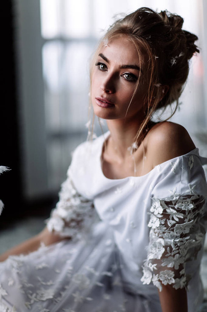 Young beautiful bride in boho style and white feathers. - Foto, imagen