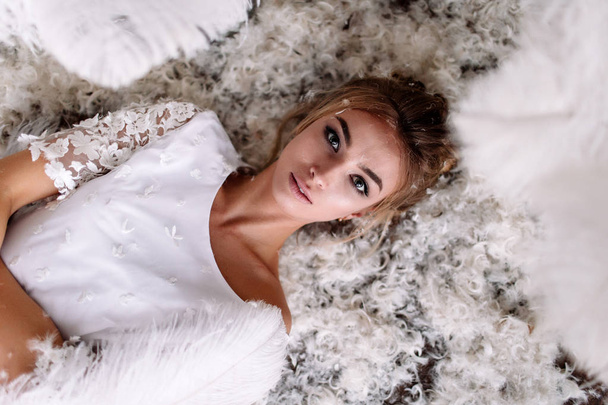 Young beautiful bride in boho style and white feathers. - Photo, Image