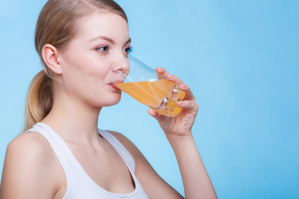 Mulher bebendo bebida com sabor de laranja ou suco
 - Foto, Imagem