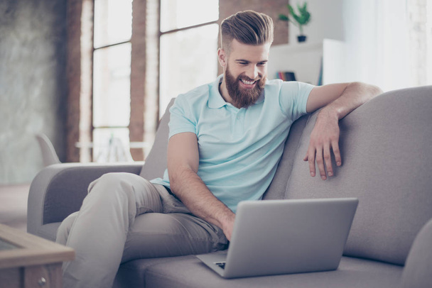 Young bearded man is making shopping online sitting at home on t - Photo, Image