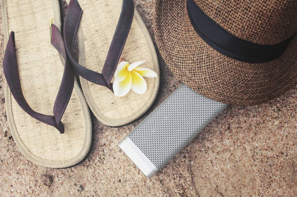 Flip flops with hat and bluetooth speaker on beach - Photo, Image