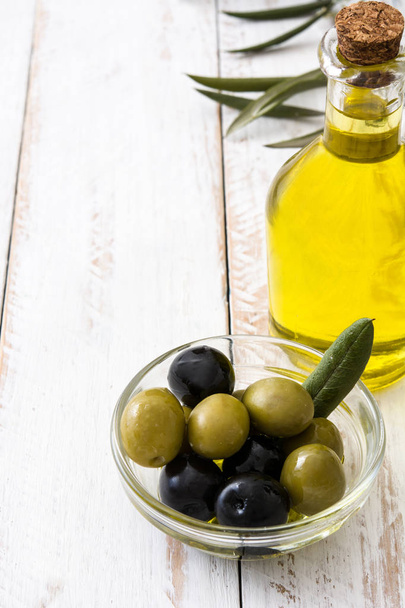 Virgin olive oil in a crystal bottle on white wooden background - Foto, Imagem