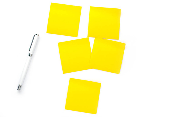 notas amarillas papel y pluma sobre fondo blanco
 - Foto, imagen