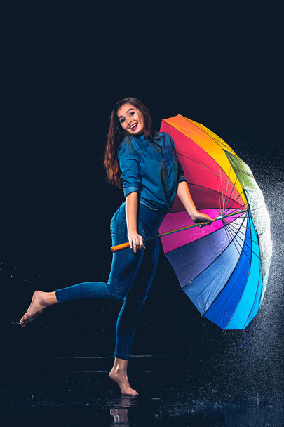 Young beautiful woman with an umbrella. - Фото, изображение