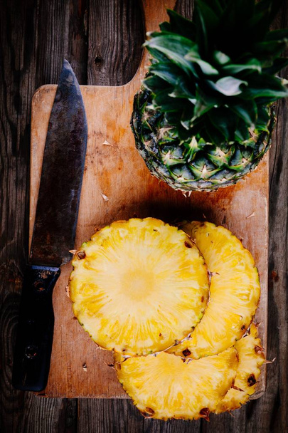 Verse rauwe biologische ananas op een houten achtergrond - Foto, afbeelding