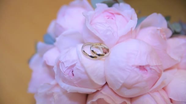 Snubní prsteny na kytici bílých květů. Snubní prsteny a kytice tmavě modrý květ. Zblízka. Svatba - Záběry, video