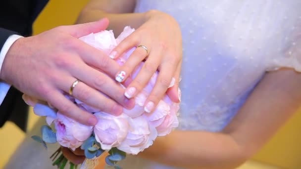 Newly wed couples hands with wedding rings. Bride and groom with wedding rings on flowers or wedding bouquet. Newly wed couples hands with wedding rings - Footage, Video