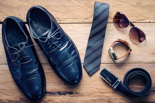 Leather shoes and accessories for work lay on the wooden floor - Fotoğraf, Görsel
