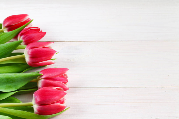 Bouquet of pink tulips on white wooden background. Top view, copy space. Happy mother's day. - Фото, изображение