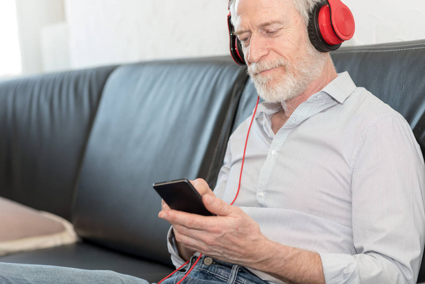 Homme mûr moderne écoutant de la musique sur téléphone mobile
 - Photo, image