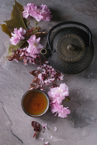 Teapot and cup of tea with blossom branch - 写真・画像
