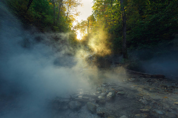 Sun rays pass through the fairy mist on the river. Dramatic colorful landscape - Foto, imagen