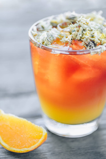 Refreshing lemonade with oranges and dry chrysanthemum on top - Фото, изображение