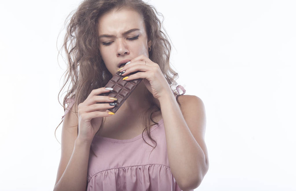 Portrait of a beautiful Woman eating chocolate. - Фото, изображение