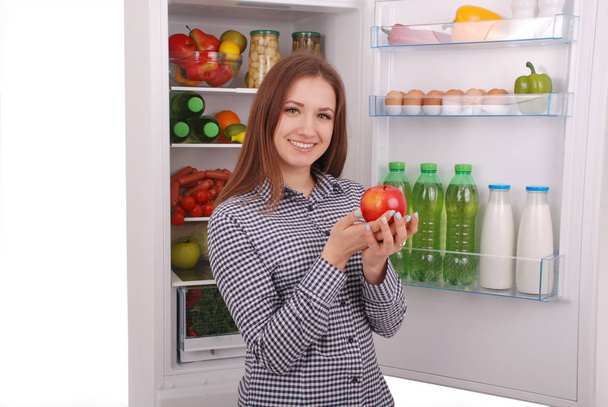 Beautiful young girl near the Fridge with healthy food. - Photo, Image