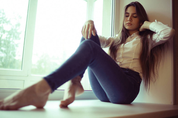 teenage girl sitting on windowsill - Fotografie, Obrázek